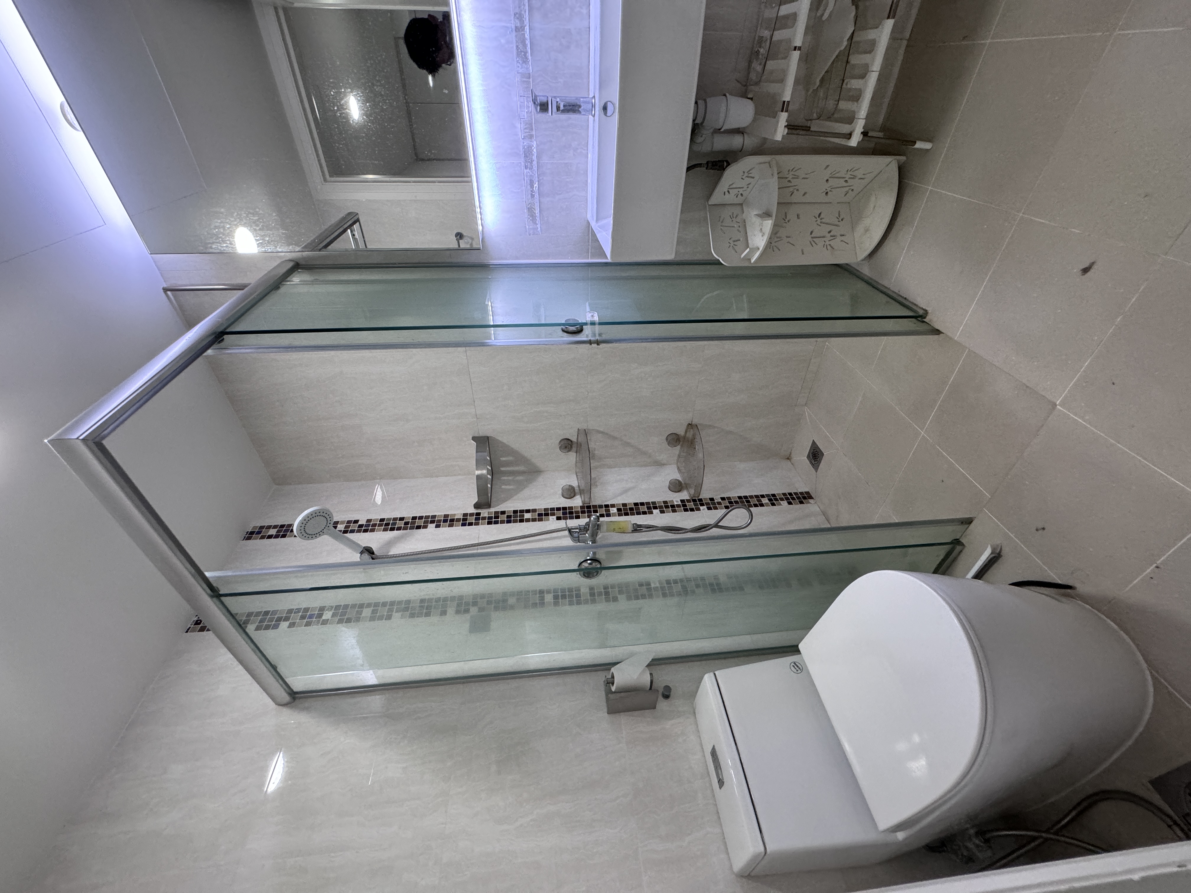 Common bathroom with glass shower enclosure